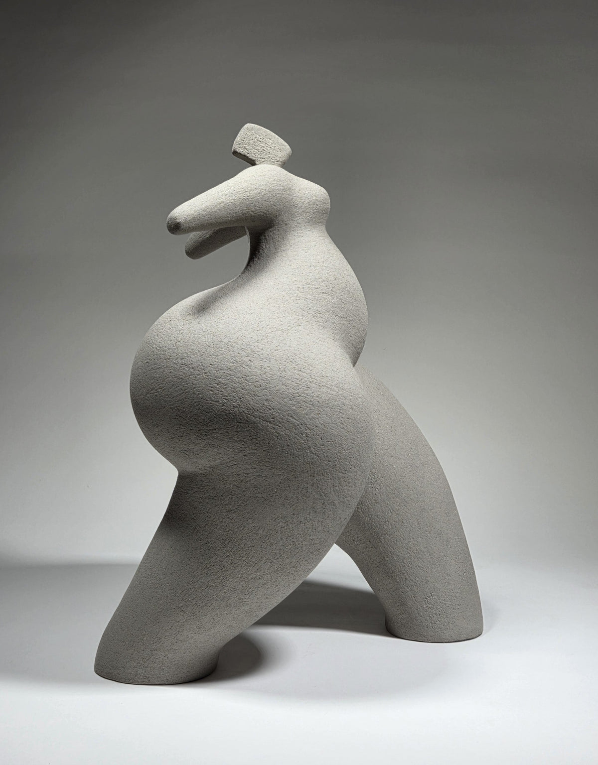 Abandon, hand-built ceramic sculpture by Rachel Peters, coiled in grey grogged stoneware, left unglazed, showing a wide-legged standing female form with arms outstretched.