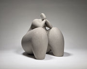 Abstract grey ceramic sculpture of a figure on a grey background