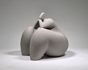 Abstract grey ceramic sculpture of a figure on a grey background