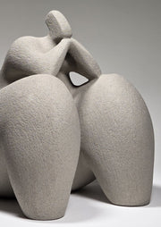 Abstract grey ceramic sculpture of a figure on a grey background