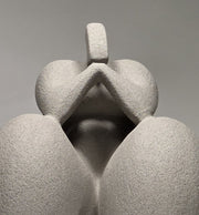 Close up of Abstract grey ceramic sculpture of a figure on a grey background