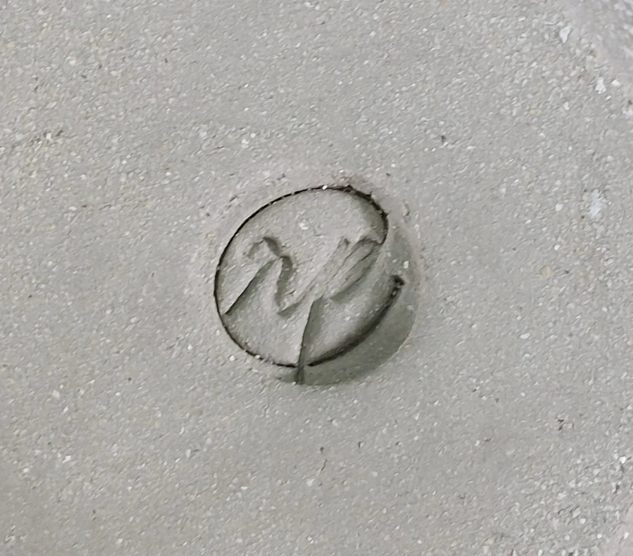 Circular logo stamp on grey clay