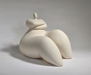 White ceramic sculpture of a reclining figure on a grey background
