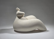 White ceramic sculpture of a reclining figure on a grey background