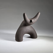 Black abstract ceramic sculpture of a figure bent backwards with arms thrown outwards titled rock star on a light grey background