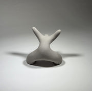 Grey abstract ceramic sculpture of a figure bent backwards with arms thrown outwards titled rock star on a light grey background