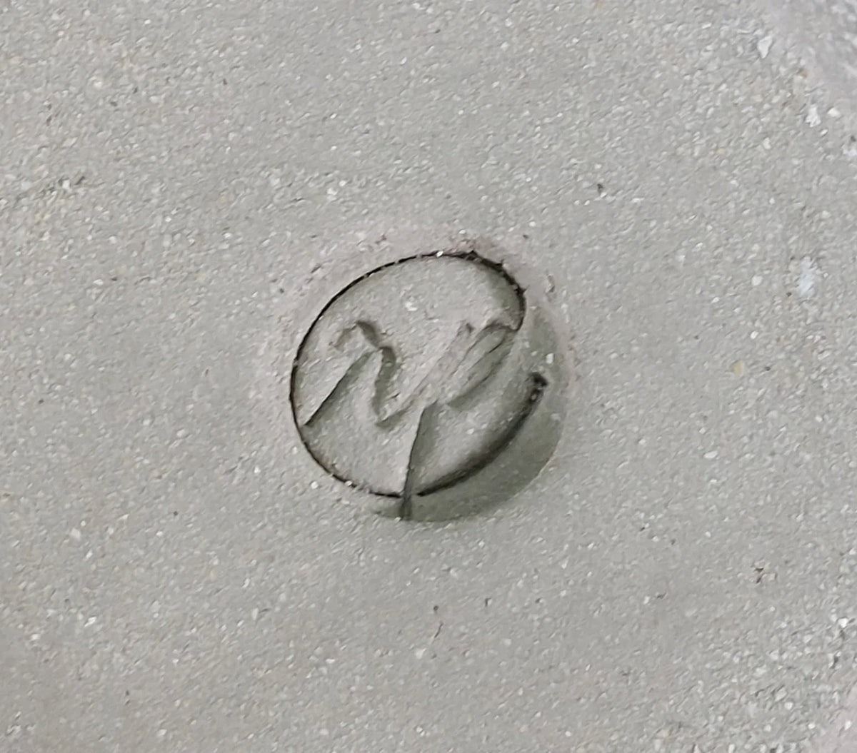Circular logo stamp on grey clay