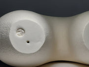 Base of An abstract figurative ceramic sculpture with rounded legs and a branching upper torso, in a matte off-white finish on a light grey studio background.