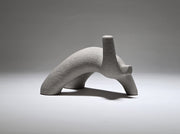 Abstract grey ceramic figure arching backwards with one arm on the floor and one stretched upwards pictures on a light grey background